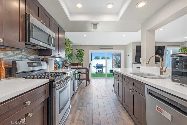 349 S Monte Vista St Unit 20, La Habra, CA 90631 - kitchen with appliances with stainless steel finishes, a sink, a raised ceiling, light wood-style flooring, and light countertops