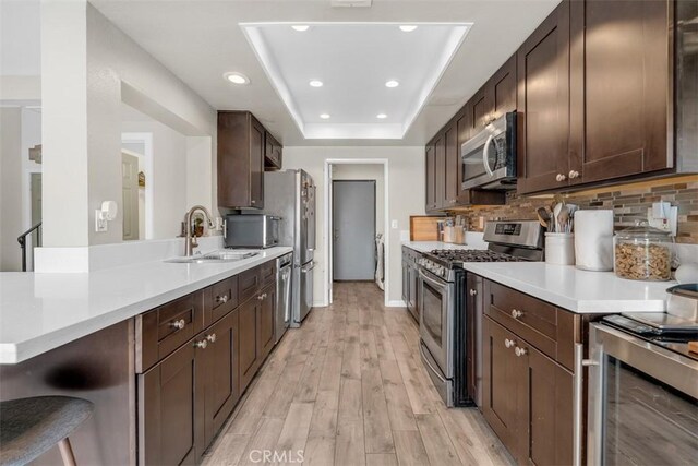 349 S Monte Vista St Unit 20, La Habra, CA 90631 - kitchen with stainless steel appliances, a sink, light wood-style floors, light countertops, and dark brown cabinetry