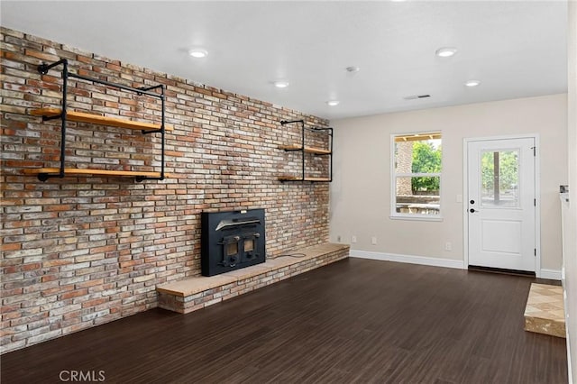 201 Valley View Dr, Oroville, CA 95966 - unfurnished living room with wood finished floors, a wood stove, baseboards, recessed lighting, and brick wall