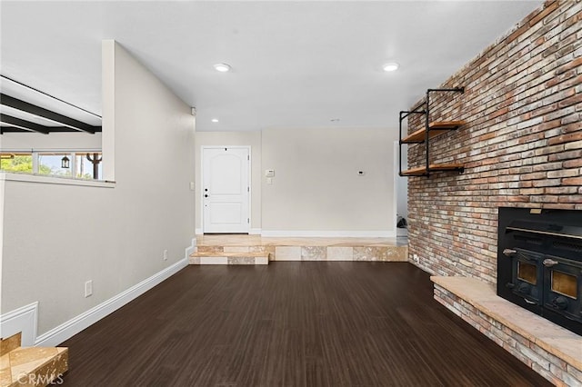201 Valley View Dr, Oroville, CA 95966 - unfurnished living room featuring baseboards, wood finished floors, recessed lighting, beamed ceiling, and brick wall