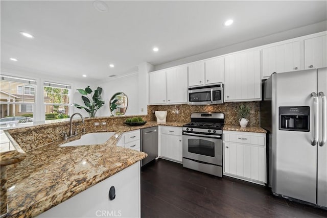 50 Bluff Cove Dr, Aliso Viejo, CA 92656 - kitchen featuring appliances with stainless steel finishes, a sink, light stone countertops, white cabinetry, and tasteful backsplash