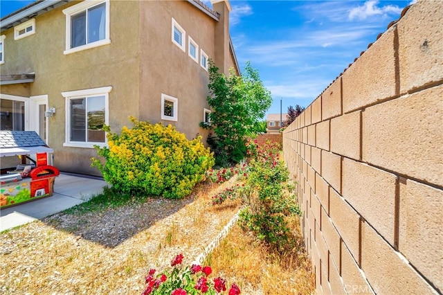 view of home's exterior featuring stucco siding and fence