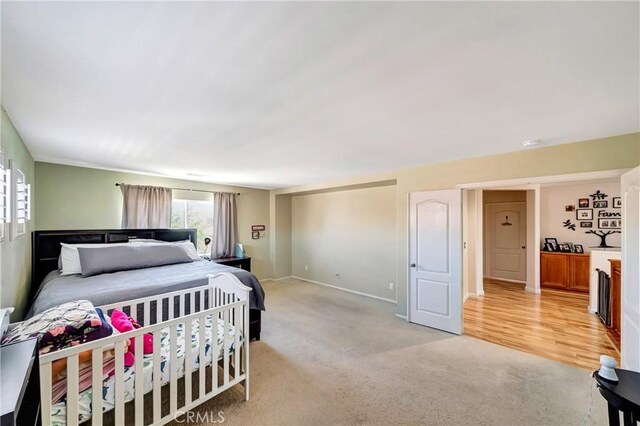 bedroom featuring light carpet and baseboards