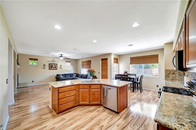 kitchen with appliances with stainless steel finishes, open floor plan, light wood-style flooring, baseboards, and recessed lighting