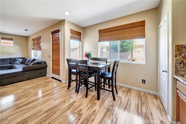 dining room featuring light wood finished floors, baseboards, and recessed lighting