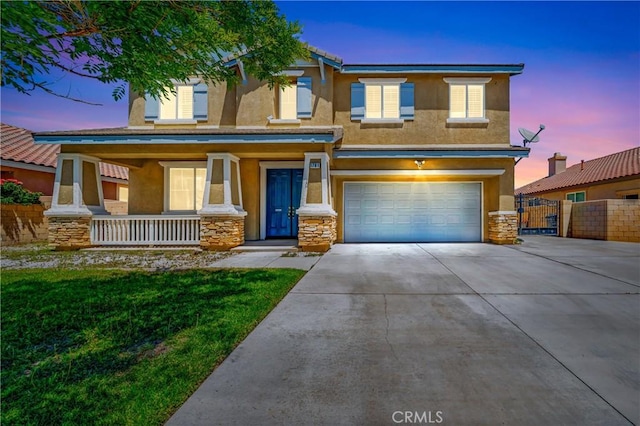 view of front of home featuring covered porch, a garage, concrete driveway, stone siding, and stucco siding