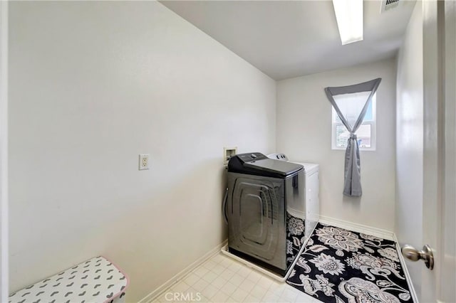 washroom featuring washer and dryer and baseboards