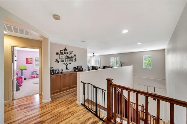 corridor featuring an upstairs landing, light wood-style flooring, recessed lighting, and baseboards