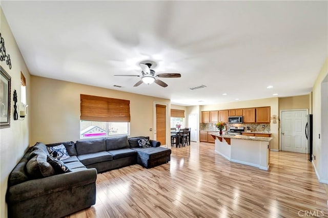 living area with a ceiling fan, light wood-style floors, and recessed lighting