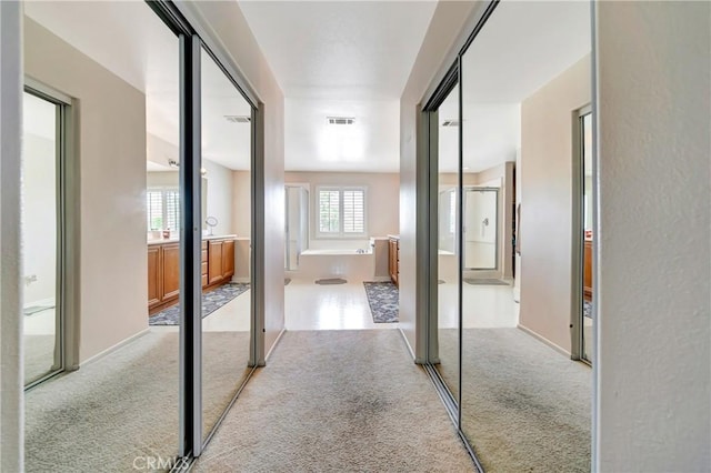 hallway with light colored carpet