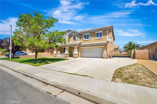 view of front of property featuring fence, stone siding, a garage, concrete driveway, and covered porch