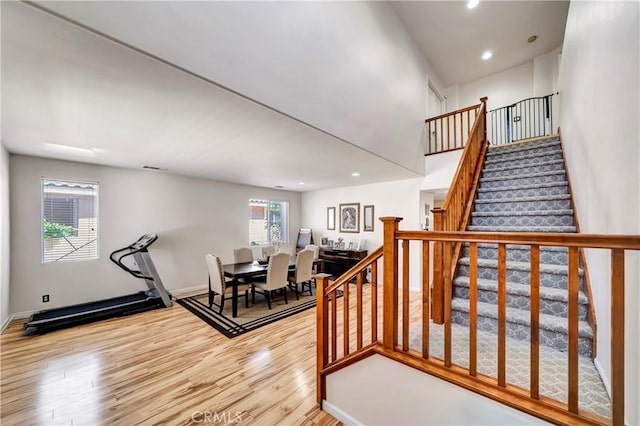 staircase with wood finished floors, recessed lighting, and baseboards