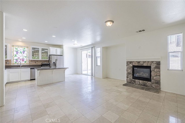 43839 58th St W, Lancaster, CA 93536 - kitchen with open floor plan, appliances with stainless steel finishes, dark countertops, white cabinets, and a kitchen island