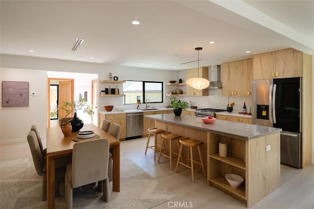 2136 Echo Park Ave, Los Angeles, CA 90026 - kitchen with open shelves, appliances with stainless steel finishes, a center island, wall chimney exhaust hood, and light brown cabinets