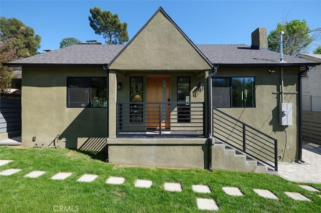2136 Echo Park Ave, Los Angeles, CA 90026 - view of front of house with stucco siding, a front lawn, roof with shingles, a chimney, and covered porch