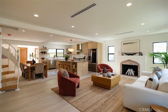2136 Echo Park Ave, Los Angeles, CA 90026 - living area featuring light wood finished floors, recessed lighting, stairs, and a fireplace with flush hearth