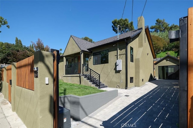 2136 Echo Park Ave, Los Angeles, CA 90026 - view of side of home with stucco siding, a chimney, and a shingled roof