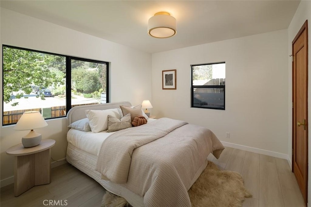 2136 Echo Park Ave, Los Angeles, CA 90026 - bedroom featuring multiple windows, light wood-style floors, and baseboards