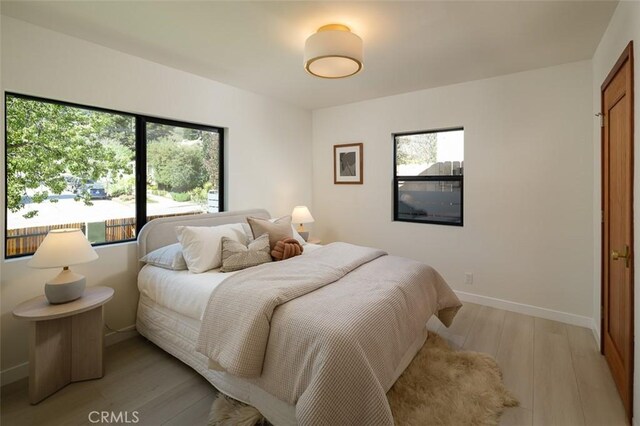 2136 Echo Park Ave, Los Angeles, CA 90026 - bedroom featuring multiple windows, light wood-style flooring, and baseboards