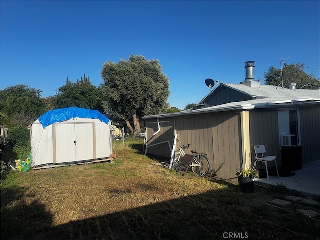view of grassy yard featuring a storage unit, an outbuilding, and cooling unit