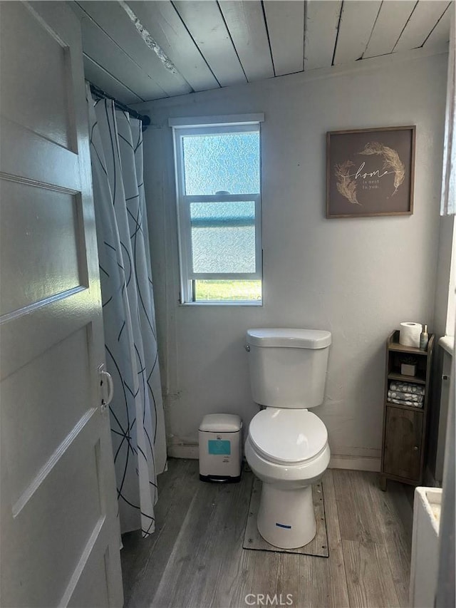full bathroom featuring wood finished floors, toilet, wooden ceiling, and a shower with shower curtain