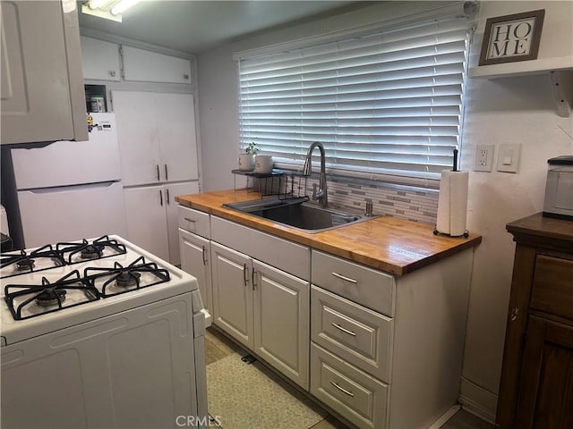 kitchen with wood counters, white appliances, a sink, and decorative backsplash