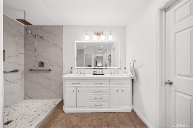 1621 Bryan Ave, Tustin, CA 92780 - bathroom featuring double vanity, a marble finish shower, wood finished floors, and baseboards