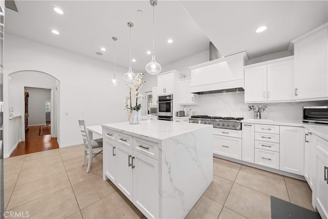 1621 Bryan Ave, Tustin, CA 92780 - kitchen featuring stainless steel gas cooktop, light tile patterned floors, premium range hood, a center island, and white cabinets
