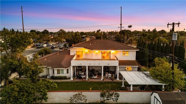 1621 Bryan Ave, Tustin, CA 92780 - back of property with a tile roof, a patio area, stucco siding, a balcony, and a lawn