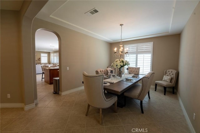 35197 Hogan Dr, Beaumont, CA 92223 - dining area featuring a raised ceiling, light tile patterned flooring, arched walkways, and baseboards