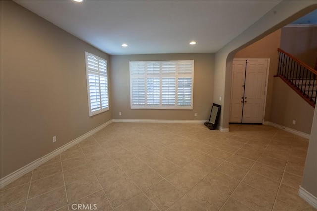 35197 Hogan Dr, Beaumont, CA 92223 - unfurnished room featuring recessed lighting, stairs, arched walkways, light tile patterned flooring, and baseboards