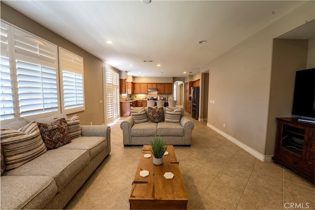 35197 Hogan Dr, Beaumont, CA 92223 - living room with arched walkways, recessed lighting, light tile patterned floors, and baseboards
