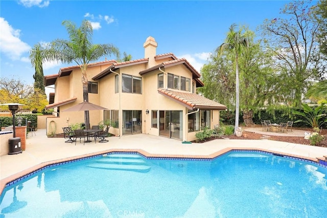 820 Rainwater Ln, Walnut, CA 91789 - rear view of property with a tiled roof, stucco siding, a chimney, and an outdoor pool