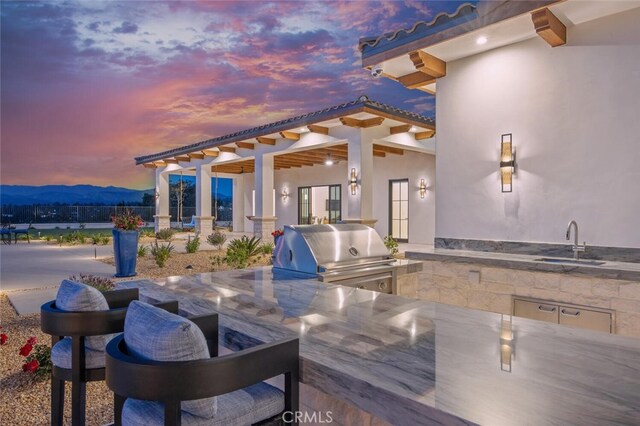 277 Crestview Ave, Camarillo, CA 93010 - patio terrace at dusk featuring exterior kitchen, area for grilling, a sink, and a mountain view