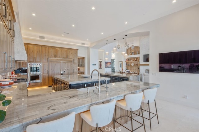 277 Crestview Ave, Camarillo, CA 93010 - kitchen featuring double oven, a large island, light stone counters, and recessed lighting
