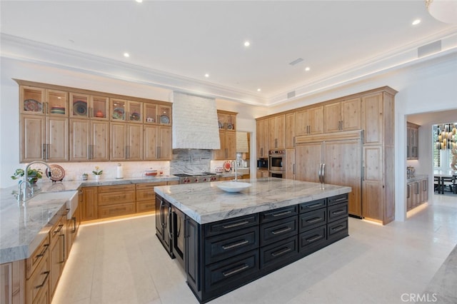 277 Crestview Ave, Camarillo, CA 93010 - kitchen featuring dark cabinetry, custom exhaust hood, decorative backsplash, a sink, and light stone countertops