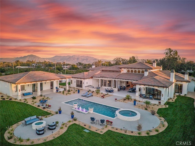277 Crestview Ave, Camarillo, CA 93010 - back of property with an in-ground hot tub, a patio area, a tiled roof, and a chimney