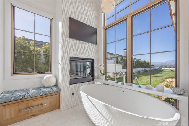 277 Crestview Ave, Camarillo, CA 93010 - full bath with healthy amount of natural light, a soaking tub, a glass covered fireplace, and tile patterned flooring