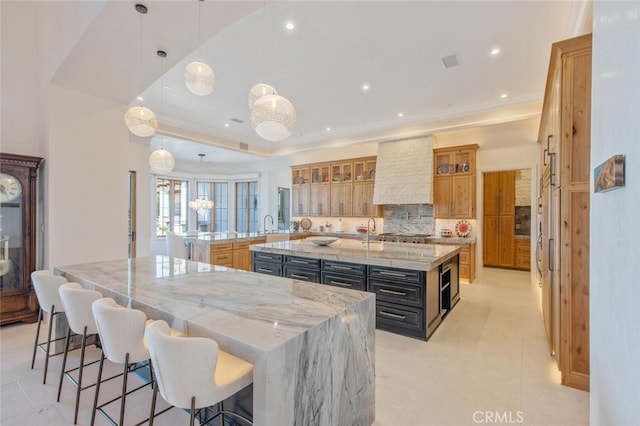 277 Crestview Ave, Camarillo, CA 93010 - kitchen with a large island, custom exhaust hood, backsplash, a kitchen bar, and recessed lighting