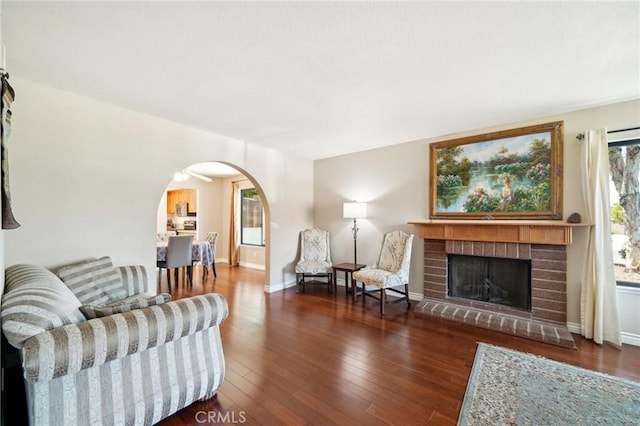 1824 S Starfire Ave, Corona, CA 92879 - living area featuring arched walkways, wood finished floors, a brick fireplace, and baseboards