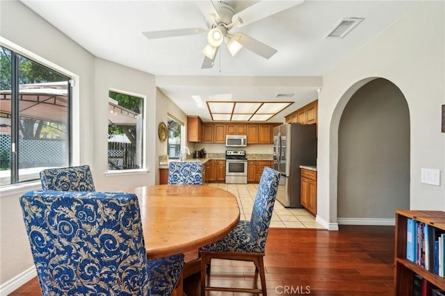 1824 S Starfire Ave, Corona, CA 92879 - dining area featuring light wood-type flooring, arched walkways, baseboards, and a ceiling fan
