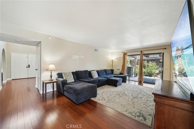 1824 S Starfire Ave, Corona, CA 92879 - living room featuring arched walkways, dark wood-type flooring, and baseboards