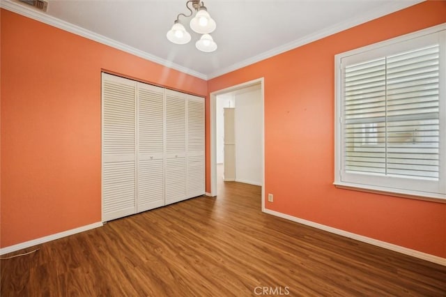 855 Dahlia Ln, San Luis Obispo, CA 93401 - unfurnished bedroom with wood finished floors, baseboards, a chandelier, crown molding, and a closet