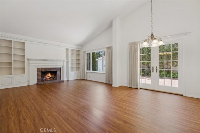 855 Dahlia Ln, San Luis Obispo, CA 93401 - unfurnished living room featuring a chandelier, a brick fireplace, wood finished floors, high vaulted ceiling, and built in shelves