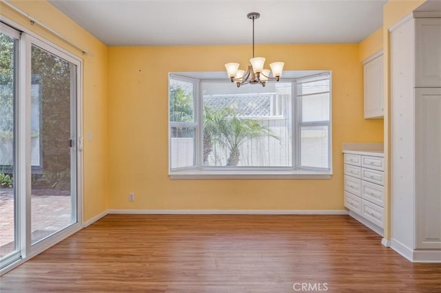 855 Dahlia Ln, San Luis Obispo, CA 93401 - unfurnished dining area with healthy amount of natural light, wood finished floors, a chandelier, and baseboards