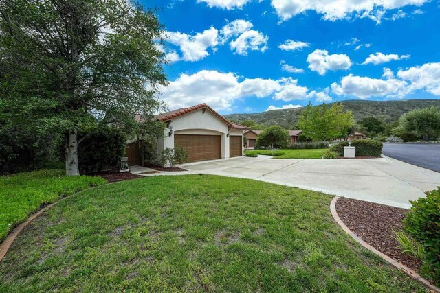 23425 Mountain Peak Rd, Ramona, CA 92065 - view of grassy yard with concrete driveway, a garage, and a mountain view