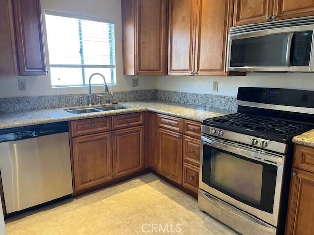 24222 Sylvan Glen Rd Unit F, Diamond Bar, CA 91765 - kitchen with appliances with stainless steel finishes, a sink, light stone counters, and brown cabinetry