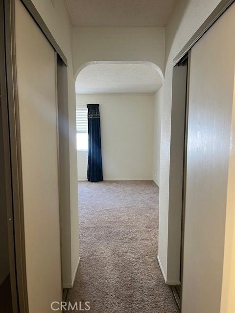 24222 Sylvan Glen Rd Unit F, Diamond Bar, CA 91765 - hallway featuring carpet flooring, arched walkways, and baseboards