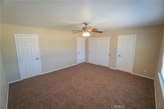 11540 Mohawk Rd, Apple Valley, CA 92308 - unfurnished bedroom featuring carpet, baseboards, two closets, a textured ceiling, and a ceiling fan