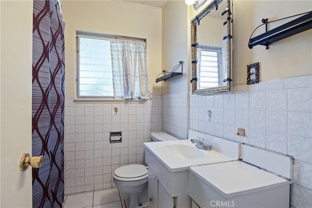full bathroom featuring toilet, tile walls, tile patterned floors, vanity, and wainscoting